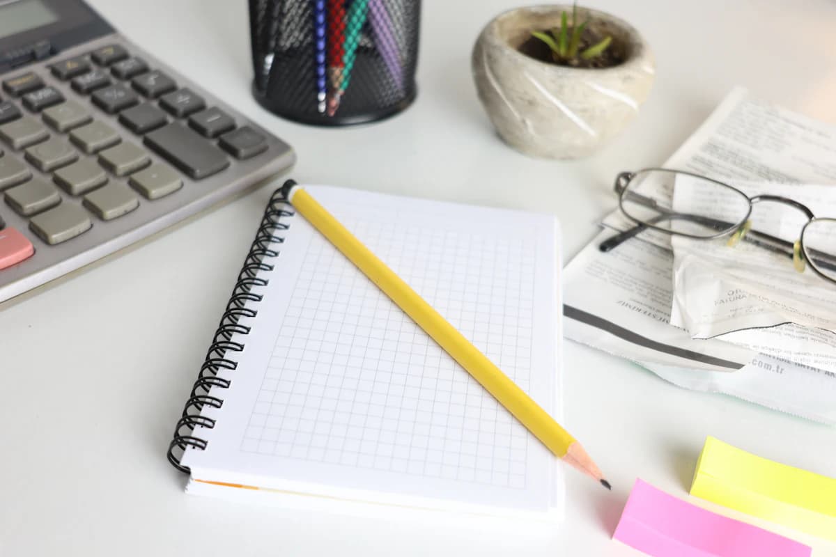 Seller planning Etsy break-even sales with a notebook, calculator, and simple chart